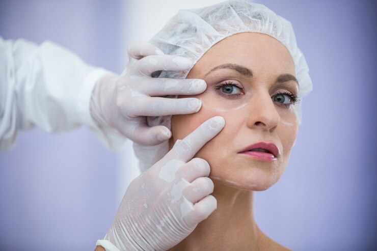 doctor-examining-female-patients-face-cosmetic-treatment_107420-74121